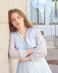 alt="Portrait Of Beautiful Young Woman Standing Outdoors"
